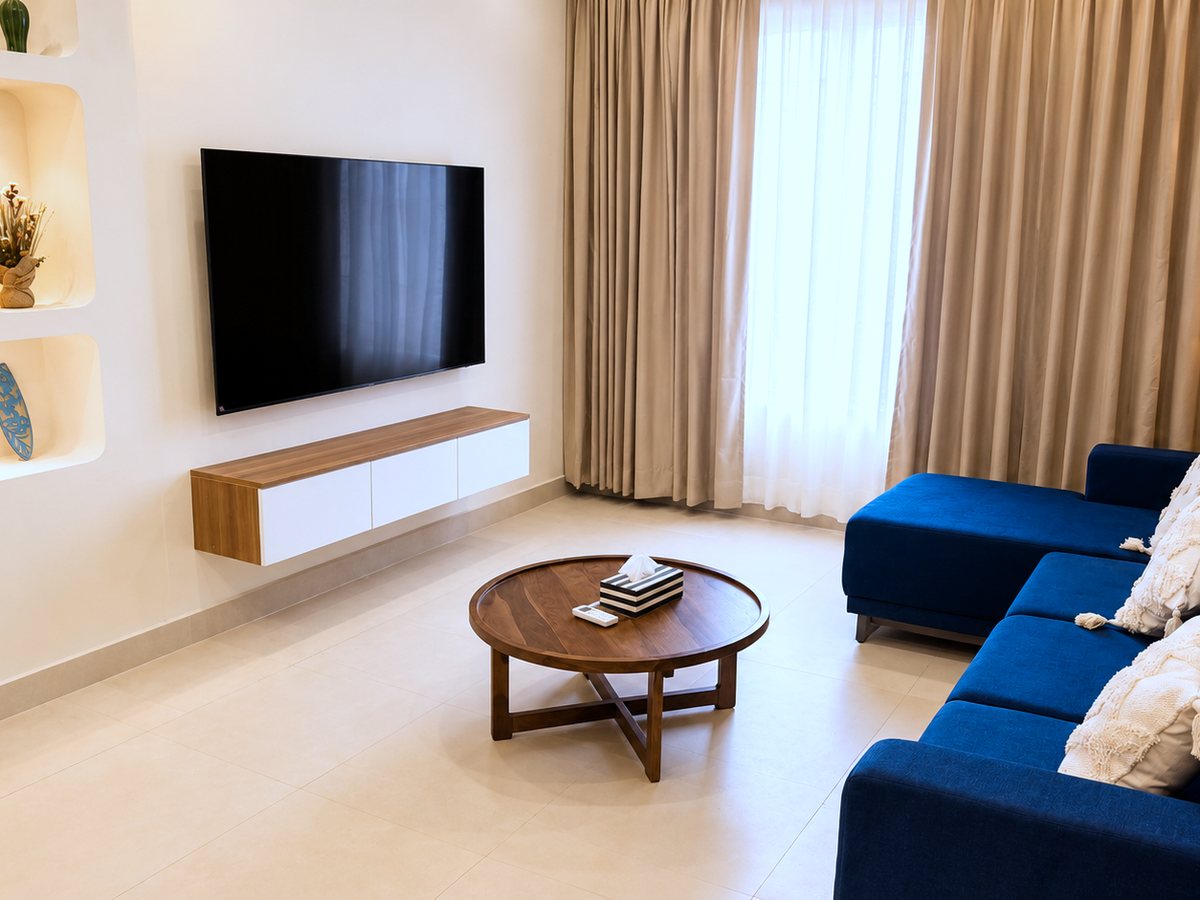 Living room with TV and seating at RYST 109A beach villa, Pearl Beach, Cheyyur